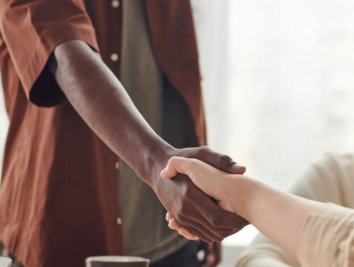 Zwei Menschen geben sich nach einem Gespräch die Hand